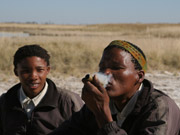 A San Bushman guide smokes from a traditional pipe as a San boy looks on at Jack's Camp in the Makgadikgadi Pans, Botswana.