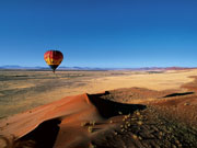 A hot air balloon offers a stunning view over the dunes at Sossusvlei, Namibia.