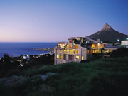 The lights of Ezard House glow against the sea on the coast near Cape Town, South Africa.