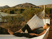 A hammock makes a perfect place to enjoy the view at Serra Cafema Camp, Kunene River, Namibia.